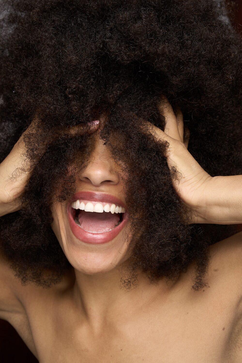Natural portrait, laughing, hands in hair
